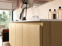 Waschplatz mit weißer Platte und geschlossenen Eichenfronten unter einer Dachschräge, dahinter verschwindet die Waschmaschine